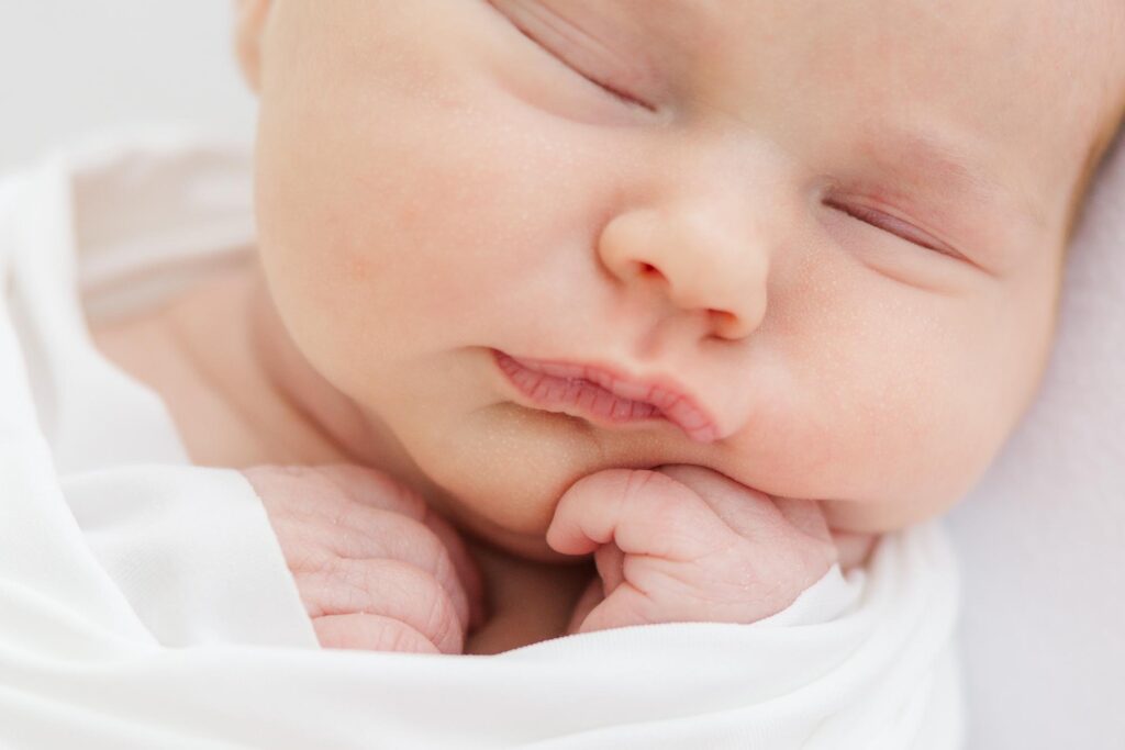 Close-up detail of a newborn baby’s lips and tiny fingers during a studio session with an Apex newborn photographer.