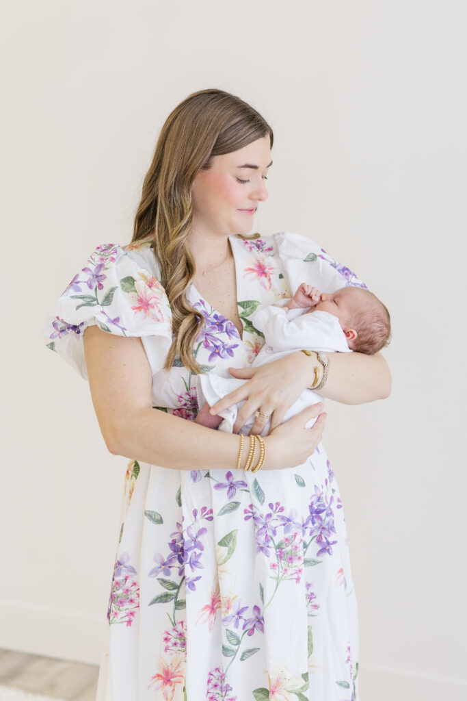 mother holding newborn in her portrait taken by raleigh studio newborn photographer