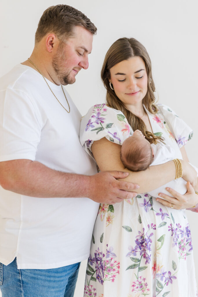 mom and dad staring lovingly at newborn in mothers arms